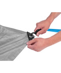 Hands securing Heavy Duty Camping Tarp 8x10 Feet Weatherproof Shelter For Outdoors to hook with grommet