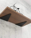 Heavy Duty Triangle Shelf Brackets 4 Pack Rock Solid Invisible Wall Supports Knockout Load Capacity Matte Black Iron Corner Braces support a wooden shelf.