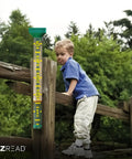 Giant 21 Inch Outdoor Rain Gauge For Pros, USA Made Heavy Duty All Weather Freeze Proof with child climbing a wooden fence