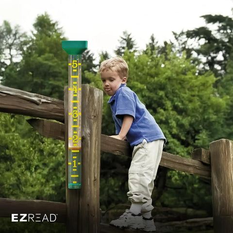 Giant 21 Inch Outdoor Rain Gauge For Pros, USA Made Heavy Duty All Weather Freeze Proof with child climbing a wooden fence