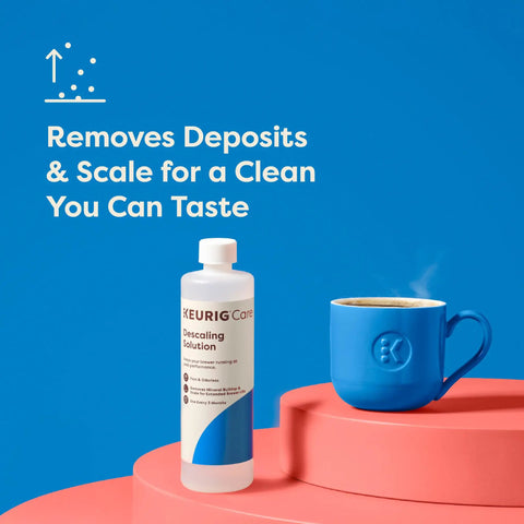 Brewer Cleanse Kit For Descaling And Maintenance With Descaling Solution next to blue coffee mug on pink platform.