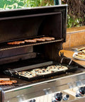 Seasoned Carbon Steel Griddle With Dual-Handle Flat Top For Stovetop, Oven, And Grill, Lightweight And Fast-Heating Pan on a grill