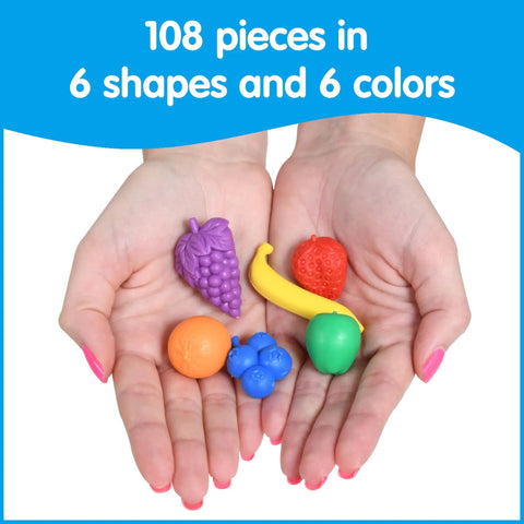 Hands holding colorful rubber fruit counters from the Fruit Counters Set Of 108 Kid Approved Rubber Math Blocks For Toddlers 3 To 5.