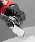 Close-up of EZARC diamond grout-removal oscillating blade on a red and black multi-tool, cutting grout.