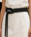 Premium Industrial Steel Punk Metal Belt In Matte Black With Easy Hook And Loop Sizing For Badass Gothic Streetwear Fits and rugged everyday flex style, styled on white dress.