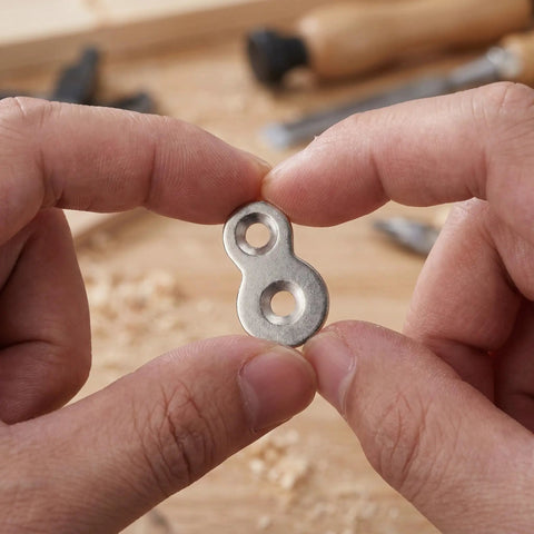 Close-up of Double Hole Tabletop Metal Connectors With Screws Prepunched Silver Fastener Plates held between fingers.