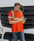 Man wearing Six Pack Safety Long Sleeve T Shirt With 360 Degree Reflective Strips Class 3 High Visibility Orange for outdoor work.