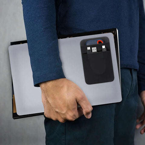 Man holding laptop with Two Pocket Portable SSD Sleeve For Laptops With Reusable Adhesive, black dual pocket case attached.