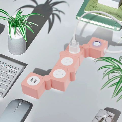 Pink Power Strip With Surge Protection, 3 AC Outlets And 2 USB Ports, Flexible Twist Design on desk with plants and keyboard