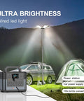 30,000 Lumen Telescoping Camping Light With Remote And Manual Control illuminating campsite with car, tent, and power station.