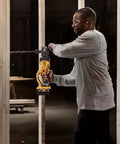 Cordless stud drill in action, user drilling through wood, featuring 20V brushless motor. Runs Like A Champ With Savage Torque For Tough Framing Work Features Power Detect Technology And E Clutch Protection Handles Bind Ups Smoothly Includes Snappy Quick Release Hex Chuck Bare Tool Only.