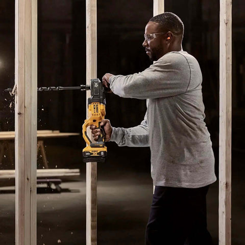 Cordless stud drill in action, user drilling through wood, featuring 20V brushless motor. Runs Like A Champ With Savage Torque For Tough Framing Work Features Power Detect Technology And E Clutch Protection Handles Bind Ups Smoothly Includes Snappy Quick Release Hex Chuck Bare Tool Only.