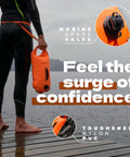 Person holding Open Water Swim Buoy With 15L Dry Bag and Rest Handle, fully waterproof swim bubble, high visibility orange.