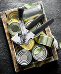 Heavy Duty Manual Can Opener With Rubber Coated Long Handles, Commercial Grade Squeeze And Crank Can Opener on a tray with cans