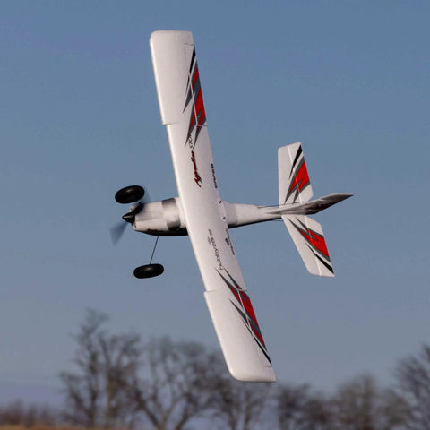 RC Airplane Apprentice STOL S 700 RTF With AS3X SAFE Technology flying mid-air showcasing its red and white wings.