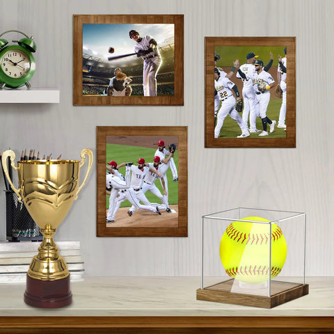 Clear Acrylic Softball Display Case With Wood Base For One Ball on shelf with framed sports pictures and trophy