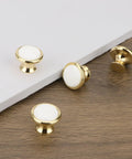 Slick Vintage White Ceramic Cabinet Knob Set Four Piece Single Hole Drawer Pulls Premium Zinc Alloy Base close-up view with gold trim