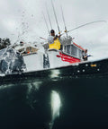 Fisherman using Rival Level Wind Conventional Fishing Reel Size 30 on a boat reeling in a fish in saltwater.