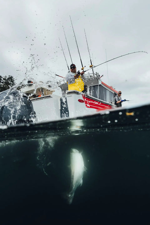 Fisherman using Rival Level Wind Conventional Fishing Reel Size 30 on a boat reeling in a fish in saltwater.