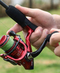 Person holding Lightweight Spinning Reel With 13 Plus 1BB For Saltwater And Freshwater Use Ultra Smooth Action CNC Aluminum Spool and Strong Graphite Frame