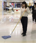Woman using Heavy Duty Commercial Mop Set With Fifty Eight Inch Handle And Three Machine Washable Cotton Loop Heads on floor.
