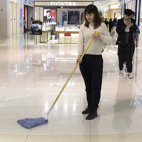 Woman using Heavy Duty Commercial Mop Set With Fifty Eight Inch Handle And Three Machine Washable Cotton Loop Heads on floor.