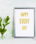 Framed artwork with gold glitter letters saying 'HAPPY EVERY DAY' beside a vase on a light background, using 8 Sheet Glitter Letter Stickers Set With Gold Vinyl Alphabet Self Adhesive Letters For Posters, Bulletin Boards, Mailboxes, Classrooms And Decor, 1 Inch And 2 Inch Sizes Waterproof Durable Indoor Outdoor.