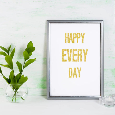 Framed artwork with gold glitter letters saying 'HAPPY EVERY DAY' beside a vase on a light background, using 8 Sheet Glitter Letter Stickers Set With Gold Vinyl Alphabet Self Adhesive Letters For Posters, Bulletin Boards, Mailboxes, Classrooms And Decor, 1 Inch And 2 Inch Sizes Waterproof Durable Indoor Outdoor.