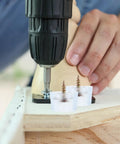 Installing Round Screw On Chair Leg Glides For Indoor Tables And Chairs No Slip PVC Furniture Feet Pads with a drill.