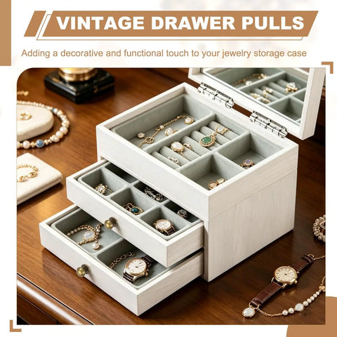 Open jewelry box with vintage drawer pulls displaying watches, rings, and bracelets on a wooden table.