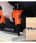 Person using Totally Badass Pneumatic Brad Nailer And Furniture Staple Gun on wood, showcasing staple application.