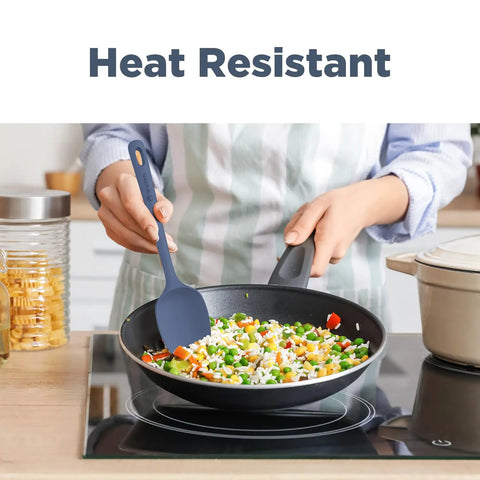 Heat resistant Top Shelf Silicone Spatula Set Five Piece Kit being used to stir vegetables in a black skillet.