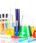 Assorted glass beakers and test tubes filled with colorful liquids, including green, blue, and yellow, displayed on a white background.