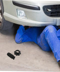 Mechanic under car with spare tire mounting screw for secure installation and durable heavy duty hold down hardware for Audi
