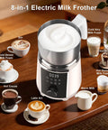 All In One Milk Frother And Steamer With Detachable Base Automatic Warm And Cold Foam Maker on a wooden table with assorted drinks.