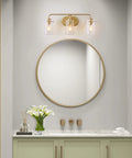 Gold Vanity Light With Seeded Glass Three Light Bathroom Fixture Modern Design hardwired above a round mirror