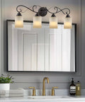 Traditional 31 Inch Four Light Vanity Light With Scrollwork Arms And Frosted Amber Glass Shades In Oil Rubbed Bronze Finish