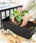 Person planting in Six Pack Railing Planter Boxes With Adjustable Brackets Black 17 Inch Deck Rail Planters For Outdoor Plants