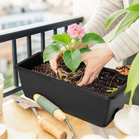 Person planting in Six Pack Railing Planter Boxes With Adjustable Brackets Black 17 Inch Deck Rail Planters For Outdoor Plants