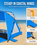 Portable Beach Sun Shelter For 2 To 8 People, UPF 50 Plus UV Protection, showing setup with guy lines, sand bags, and stakes on beach.