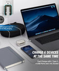All In One Global Travel Adapter for Europe UK Australia and US on desk with laptop and phone charging