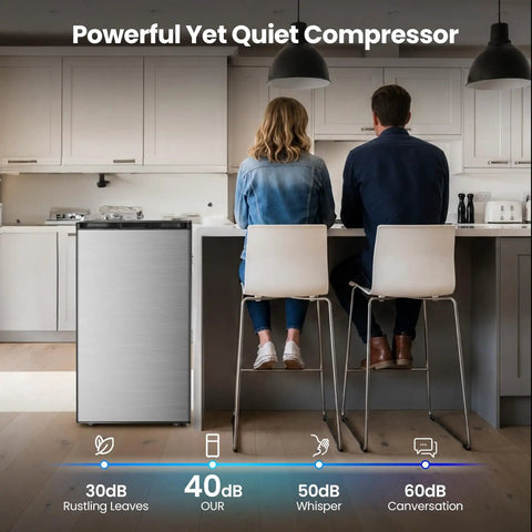 Compact 3.0 Cu Ft Upright Freezer In Silver With Moveable Shelves And A Lean Vertical Build Made For Tight Apartments Or Small Kitchens, beside two people at a kitchen counter.