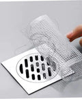 Disposable Hair Drain Stickers placed over a drain, demonstrating self-adhesive fine mesh cover for shower use.