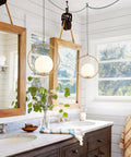 Large White Glass Globe Pendant Light With Plug In Cord Brushed Gold Ring Mid Century Modern Style For Kitchen Island Minimalist Hanging Lamp For Dining Room And Living Spaces hanging in a bathroom above a double sink vanity.