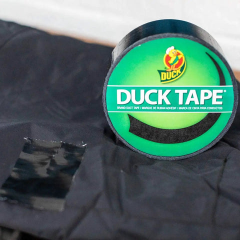 Roll of black color duct tape for all purpose heavy duty projects, shown with taped fabric, removable up to three weeks use
