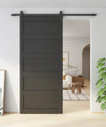 Ultra Sharp 42 By 96 Inch Wave Shape Sliding Barn Door In Matte Black with hardware in a modern living room setting.