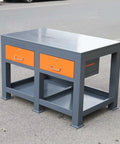 Industrial Grade Steel Workbench Featuring Two Secure Locking Drawers And Quick Access Shelf in gray and orange with flat surface.