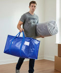Person holding Ultra Large Moving Bags With Heavy Duty Zippers And Sturdy Carry Handles Waterproof Storage Bags For Moving Closet Organization And Camping 16 Pack Blue