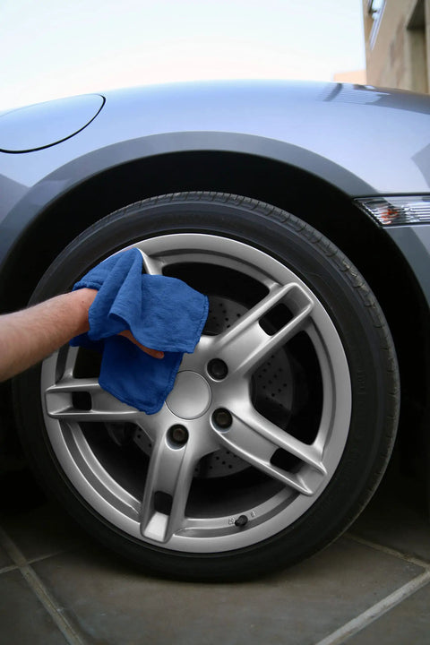 Person wiping car wheel with blue cotton towel from 150 Pack Cotton Shop Towels 14 By 12 Inches Absorbent Rags For Auto Shops Garage Home And Industry Cleaning Multipurpose Reusable Towels For Spills Machinery Wipe Downs And General Cleanup Blue