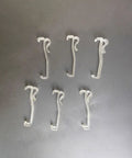 Twelve Pack Transparent Valance Clips For Window Blinds, clear plastic clips arranged on a dark surface, ideal for easy window treatment installation.